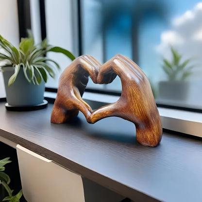 Heart-shaped resin sculpture decor by Nutshell featuring two wooden hands forming a heart on a windowsill