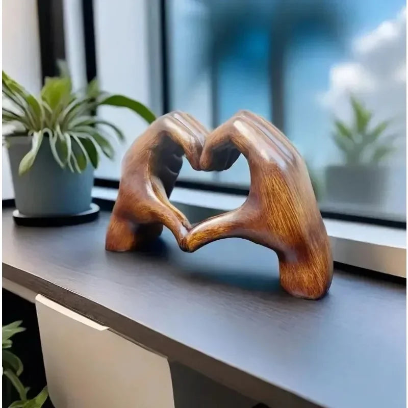 Unique heart-shaped resin sculpture decor featuring two hands forming a heart on a modern shelf