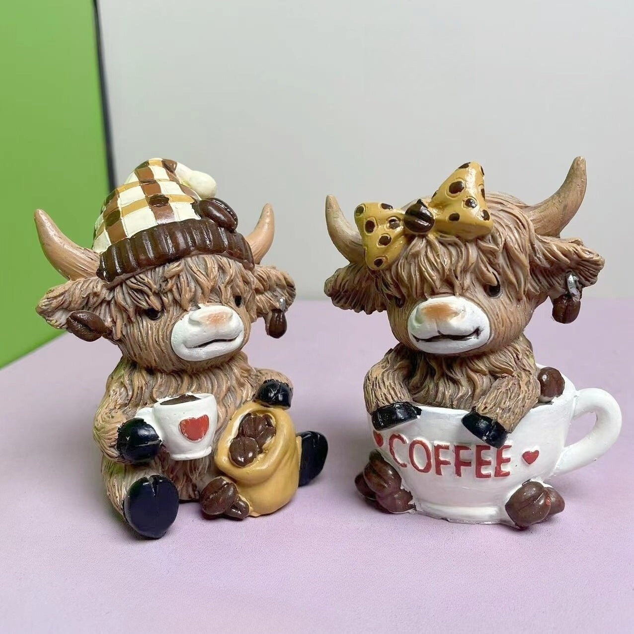 Adorable Highland Cow Coffee Decor Figurines holding coffee mugs with playful expressions