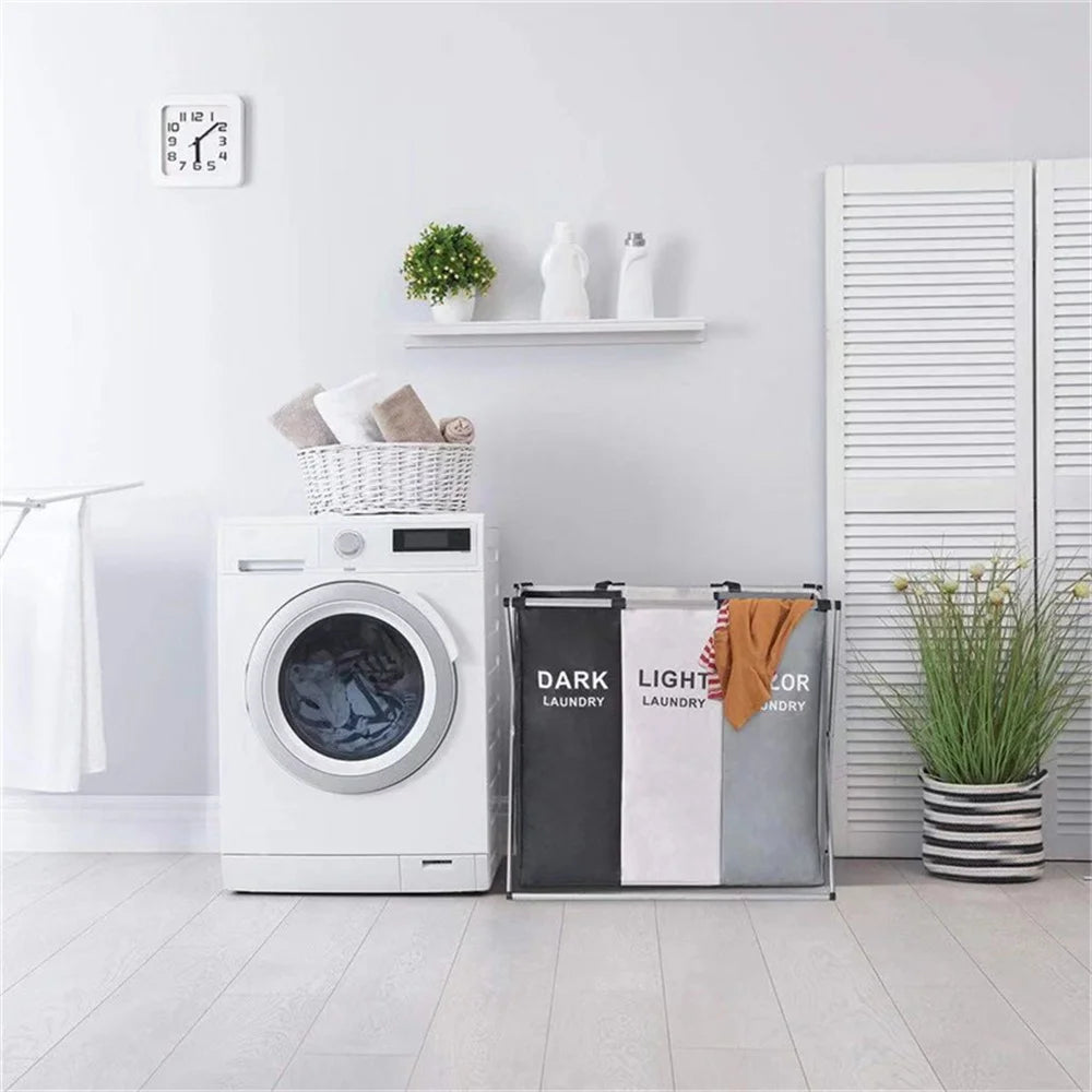Nutshell 3 grid laundry hamper with dark light color sorting bins beside white front load washer in modern laundry room