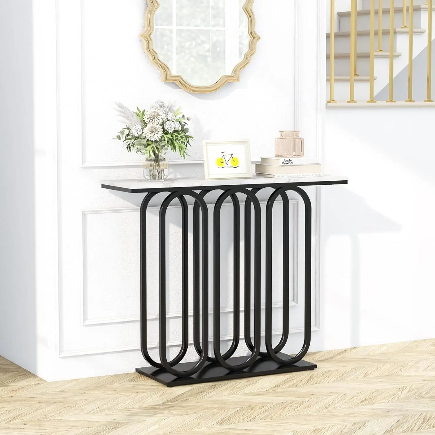 Nutshell faux marble console table with white marble top and black geometric looped metal base in foyer