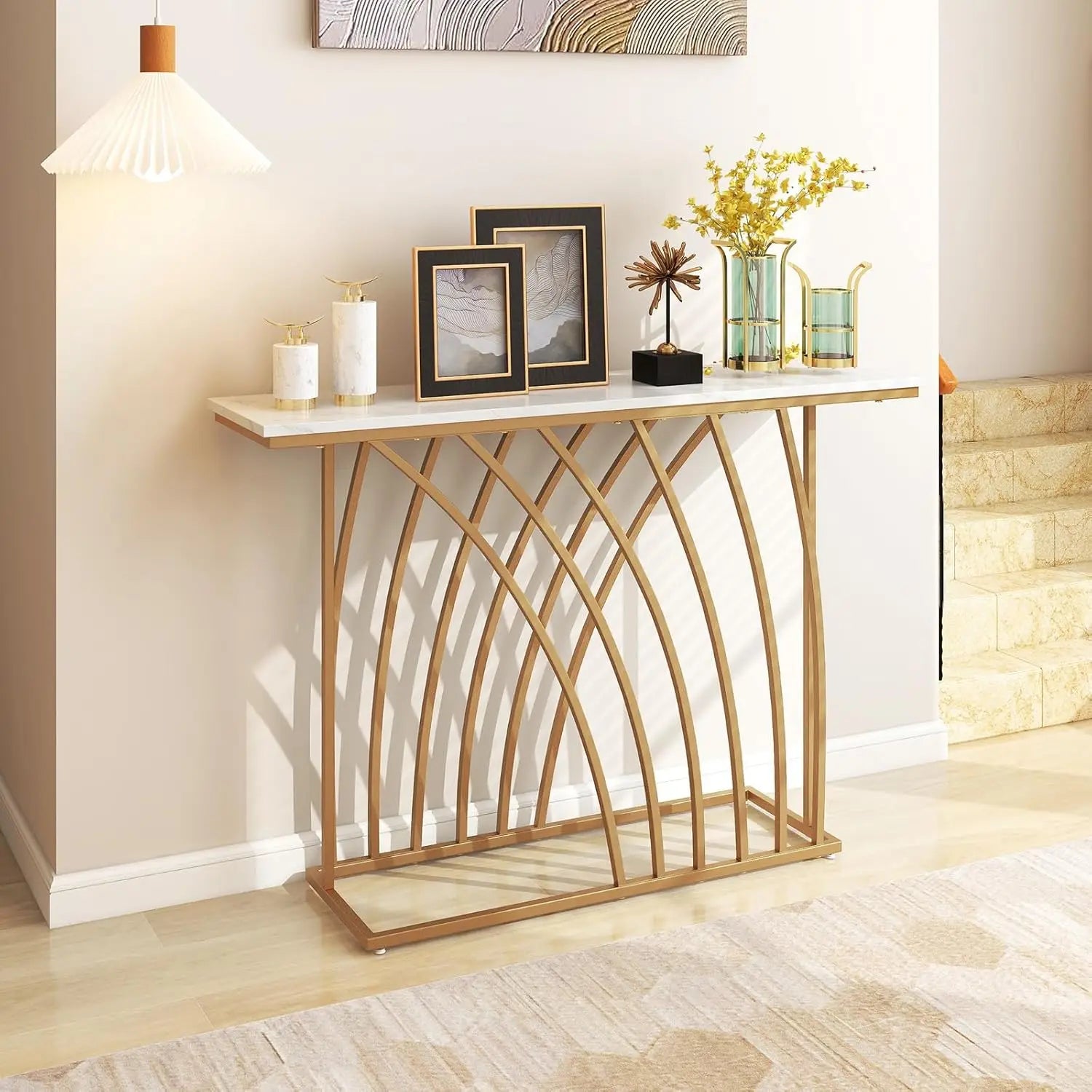 Nutshell modern gold console table with white marble top and arched metal base in styled entryway
