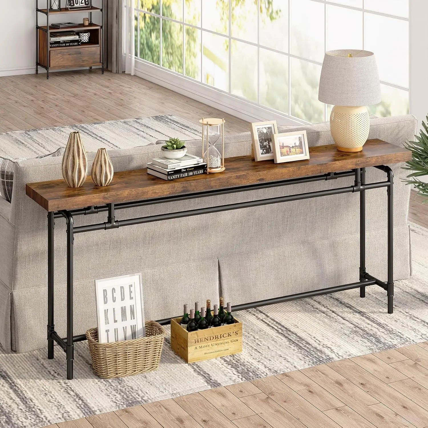 Extra Long Sofa Table by Nutshell rustic wood top with black metal pipe frame placed behind beige sofa in living room