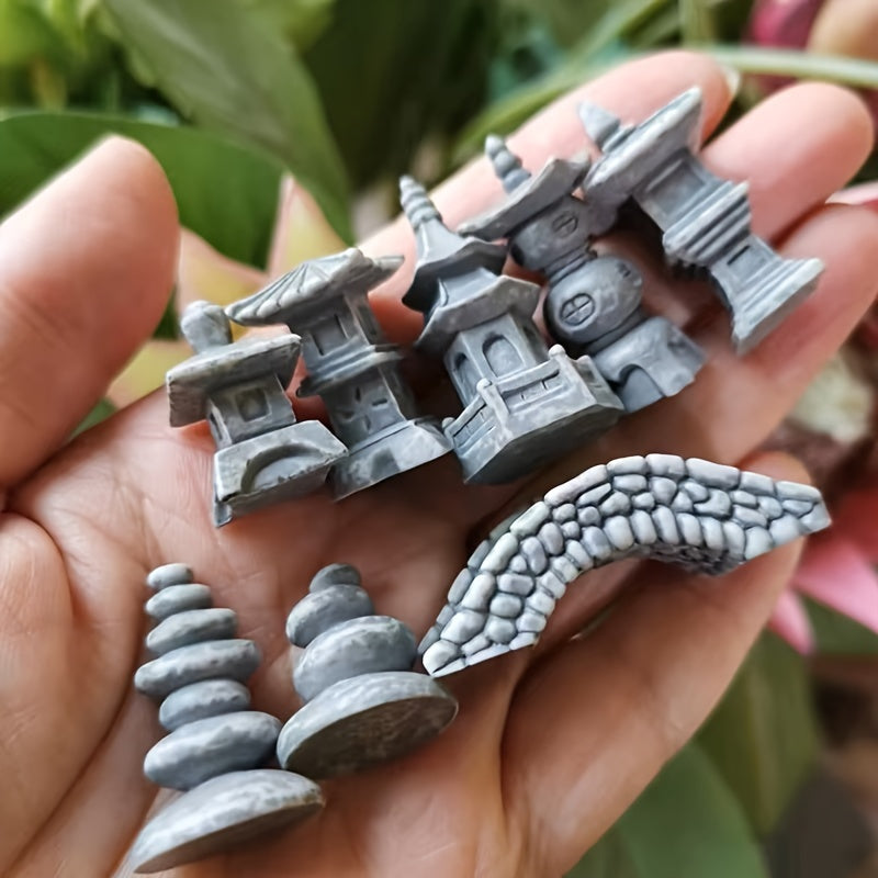 Assorted Japanese zen garden bridge models and decorative features held in a hand