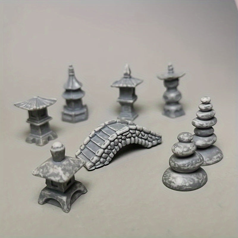 Miniature Japanese zen garden bridge models with stone pagodas and rock features for peaceful landscaping
