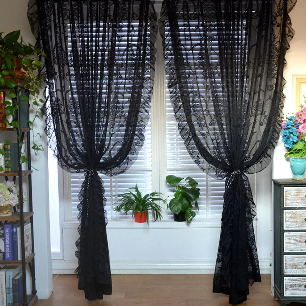 Nutshell black vintage voile ruffle lace drapes tied back over white blinds with potted plants