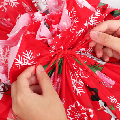Two hands tying a large Christmas gift bags with festive holiday designs and snowflakes
