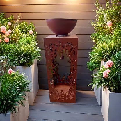 Large red iron flower pot set among lush green plants for a vibrant garden display