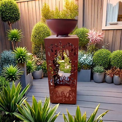 Large red iron flower pot with intricate design surrounded by greenery on a patio