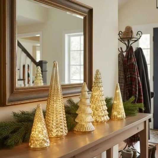 Decorative LED glass Christmas tree decor displayed on a console table with a mirror reflection