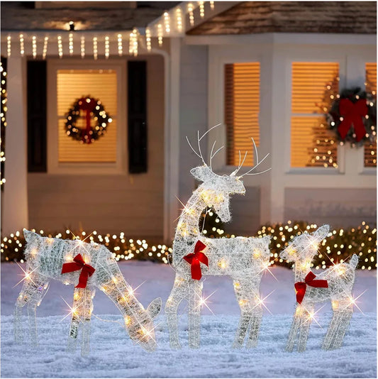 Lighted deer Christmas outdoor decoration featuring three reindeer with festive bows in front of a decorated house