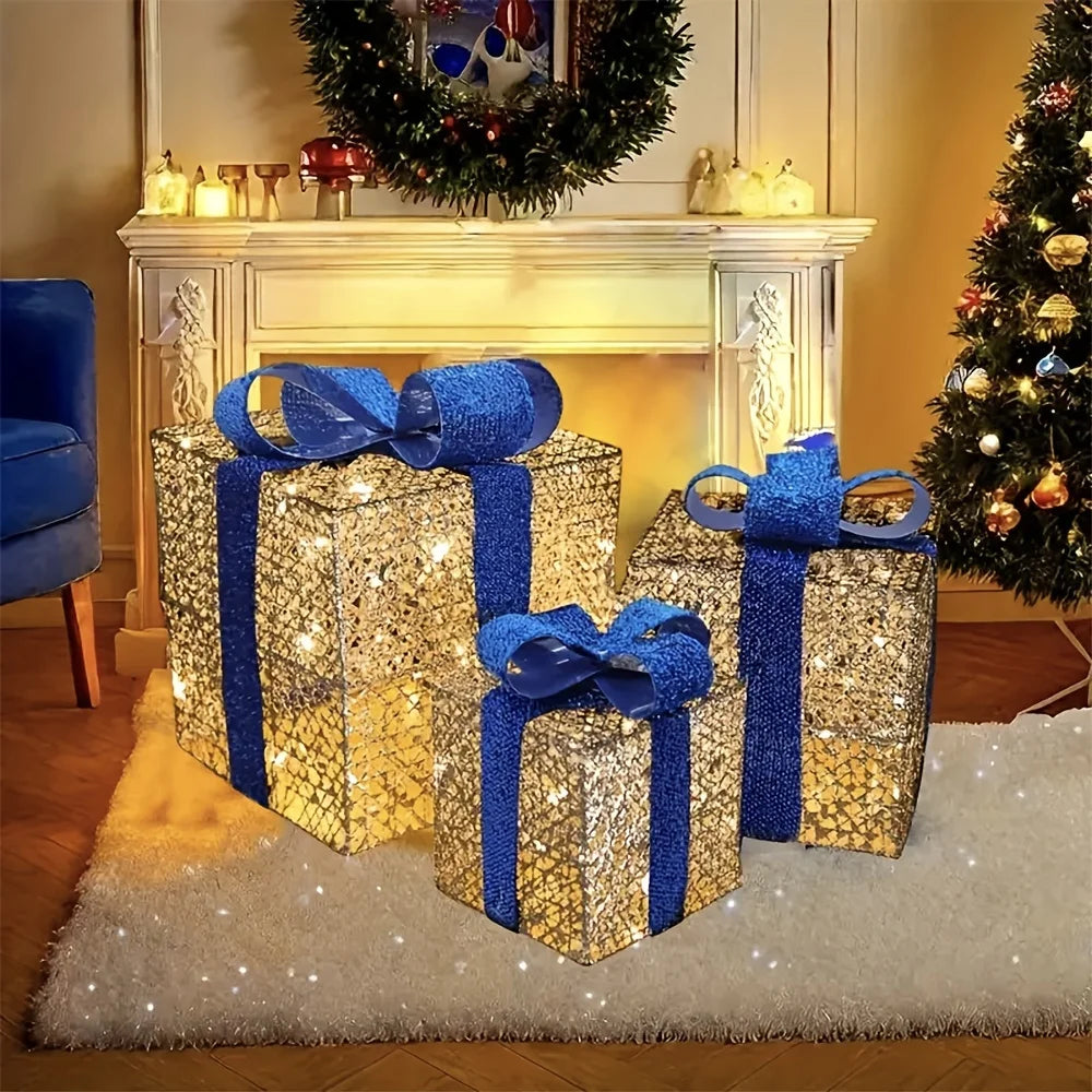 Luminous Christmas gift box decorations in blue and gold, placed beside a decorated tree and fireplace