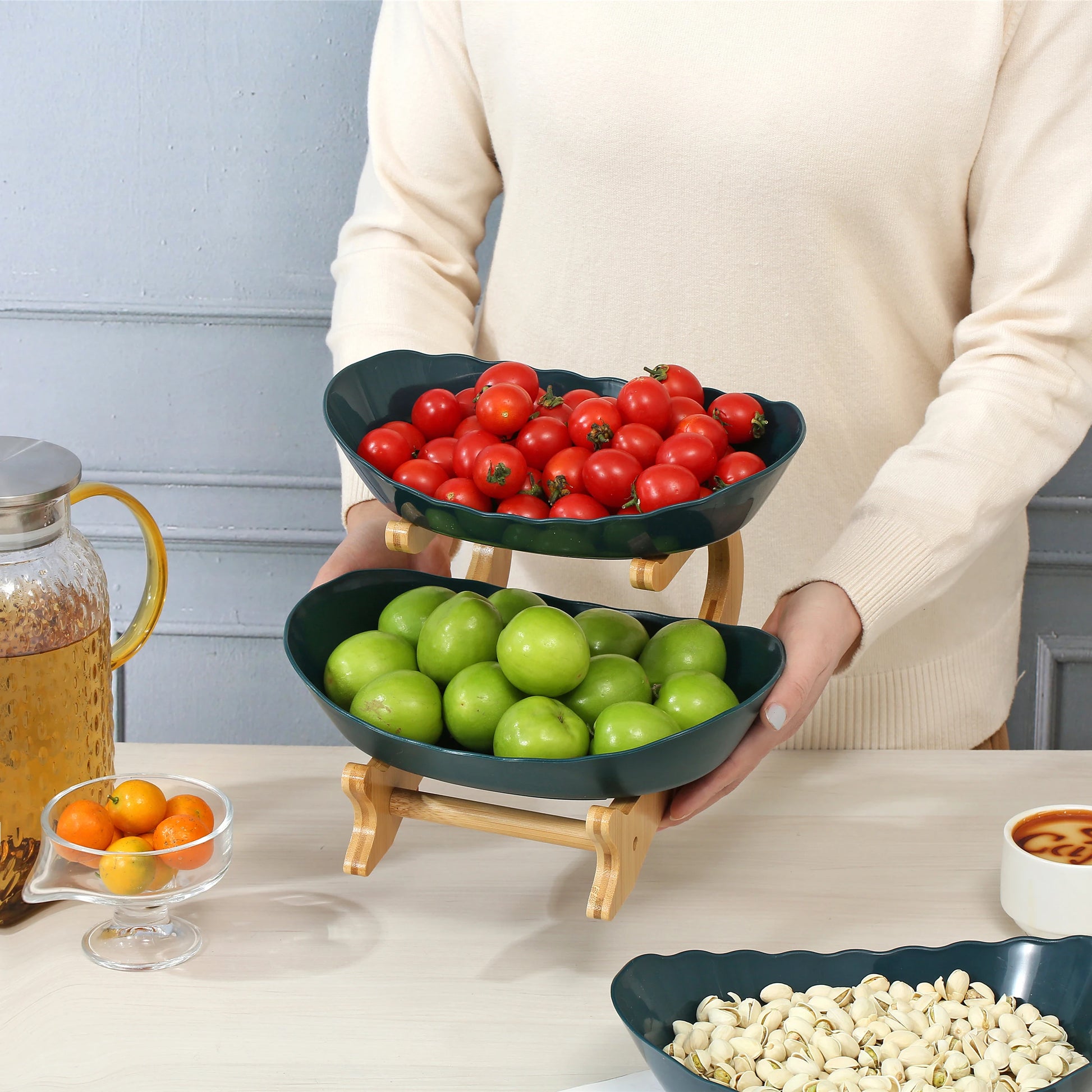 Nutshell multi-tier serving stand fruit bowl with green apples and red cherry tomatoes in two tiered black bowls on wooden frame