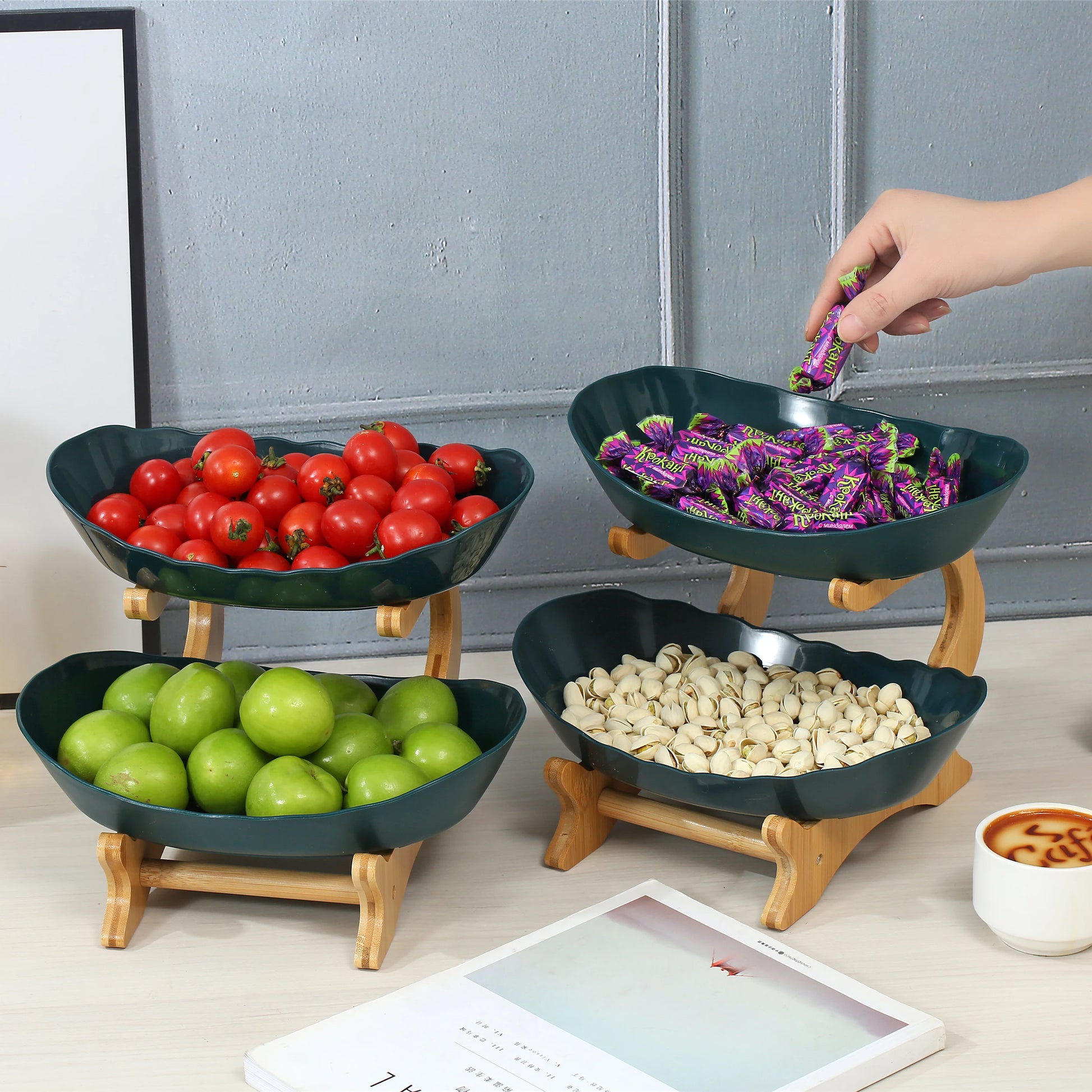 Nutshell multi-tier serving stand with four green fruit bowls holding tomatoes, green apples, candy, and nuts on wooden stands