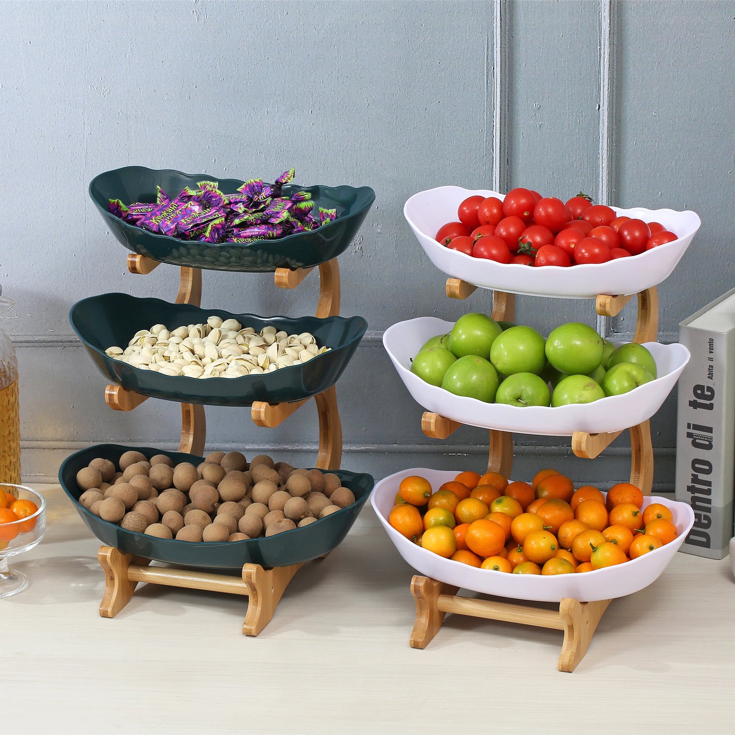 Nutshell multi-tier serving stand holding colorful fruit and nuts in black and white bowls