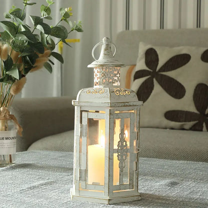 Nutshell vintage candle holder lanterns in distressed white metal with intricate detailing and lit candle inside