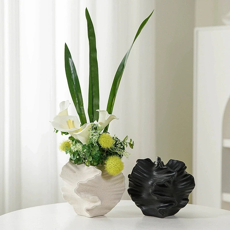 Nutshell Nordic art coral vase in white with green and white flowers next to black Nordic art coral vase