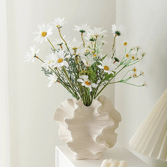 Nordic art coral vase by Nutshell in beige with ruffled edges holding white daisies
