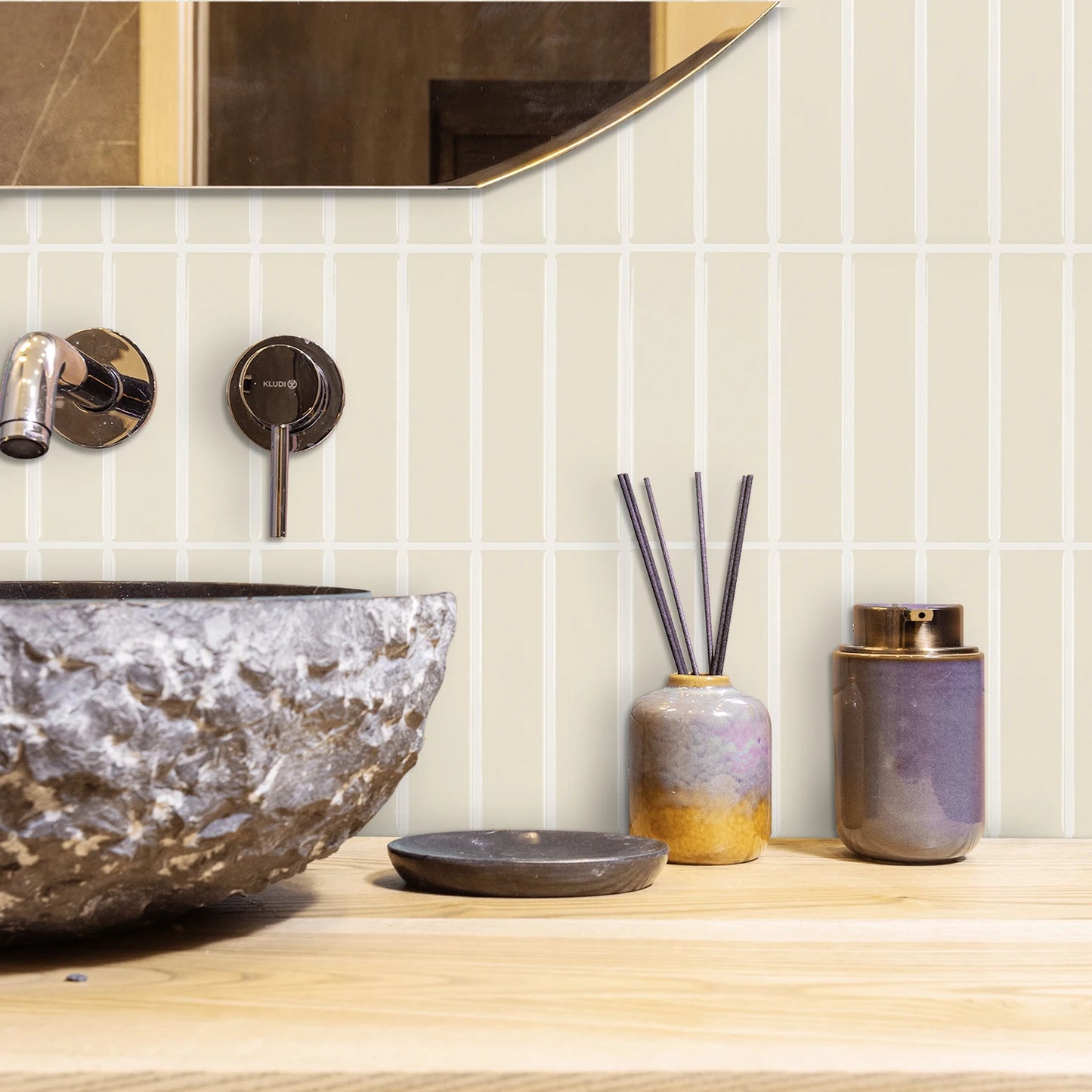 Nutshell DIY Backsplash Tiles in cream vertical layout behind stone vessel sink and decorative jars