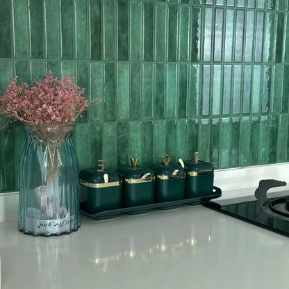 Nutshell DIY Backsplash Tiles in glossy green vertical subway pattern behind kitchen counter with canisters