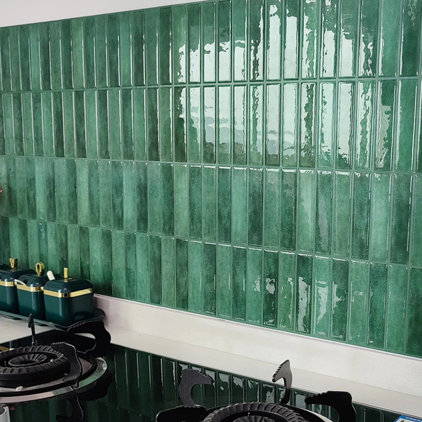 Nutshell DIY Backsplash Tiles glossy green vertical subway tiles behind stovetop with teal canisters
