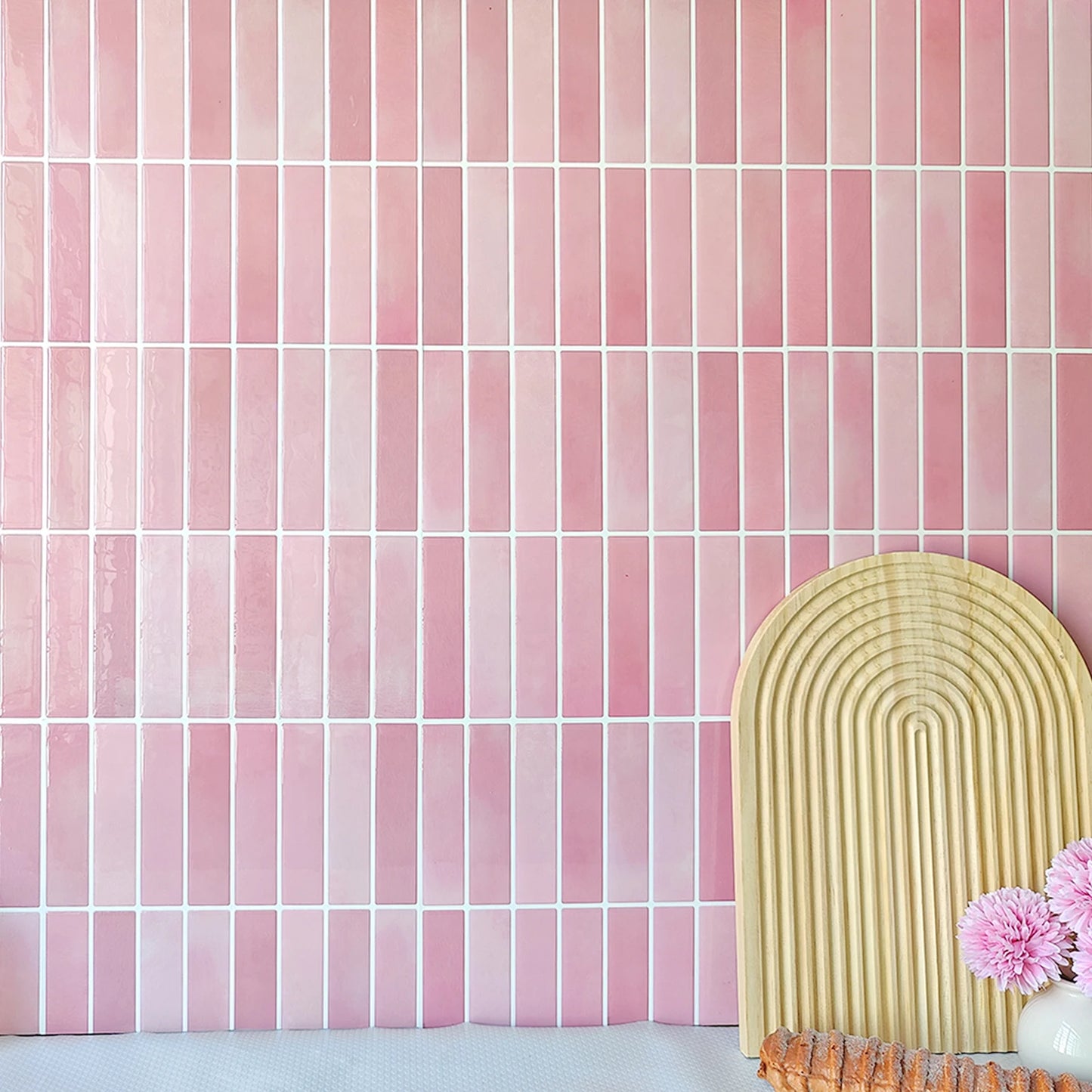 Nutshell pink vertical rectangular DIY Backsplash Tiles with white grout shown with decorative arch board and flowers