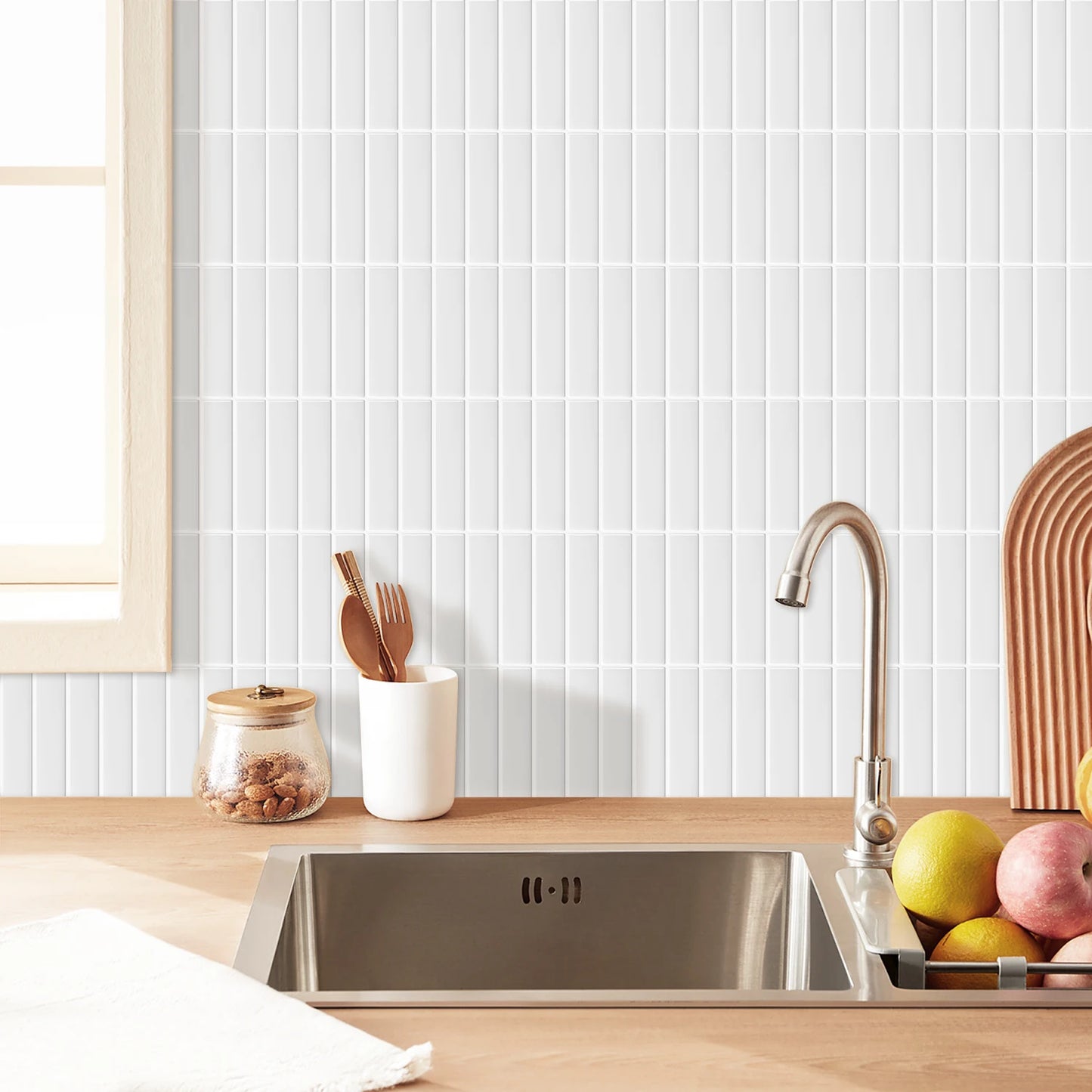 Nutshell kitchen sink with white vertical subway DIY Backsplash Tiles on wooden countertop with utensils and fruit