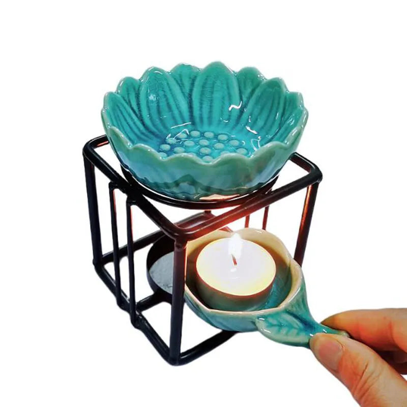 Porcelain lotus essential oil burner by Nutshell with teal flower design and metal frame with candle holder