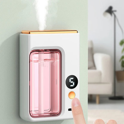 Nutshell portable diffuser with digital timer and pink water tank emitting mist on wall near living room
