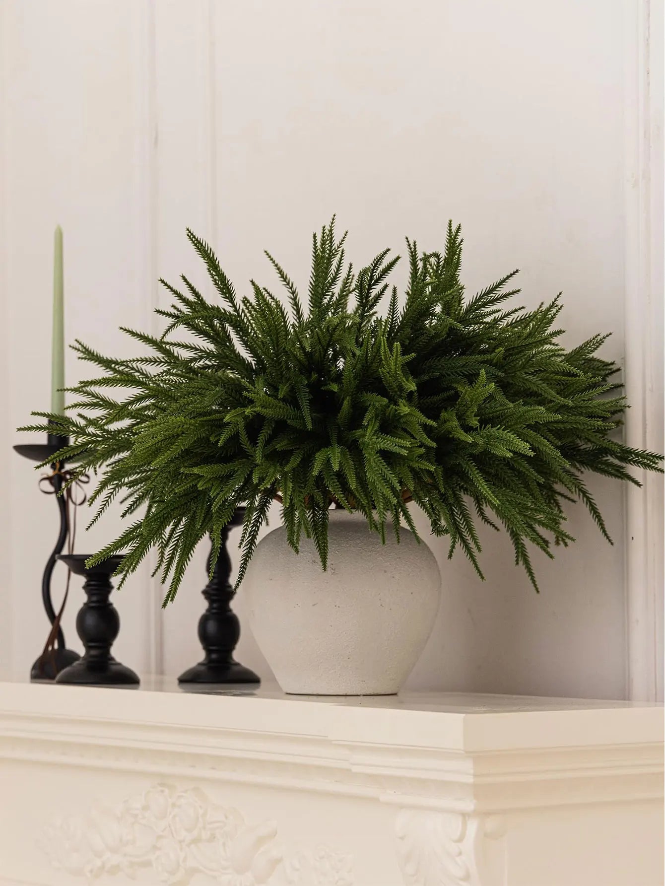 Nutshell real touch faux pine branches in a stylish vase on a white mantel with candles