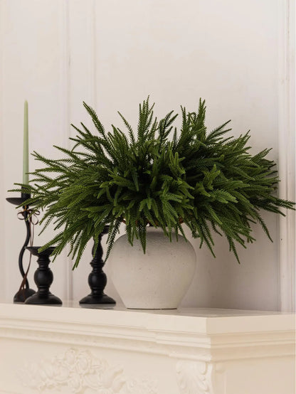 Nutshell real touch faux pine branches in a stylish vase on a white mantel with candles