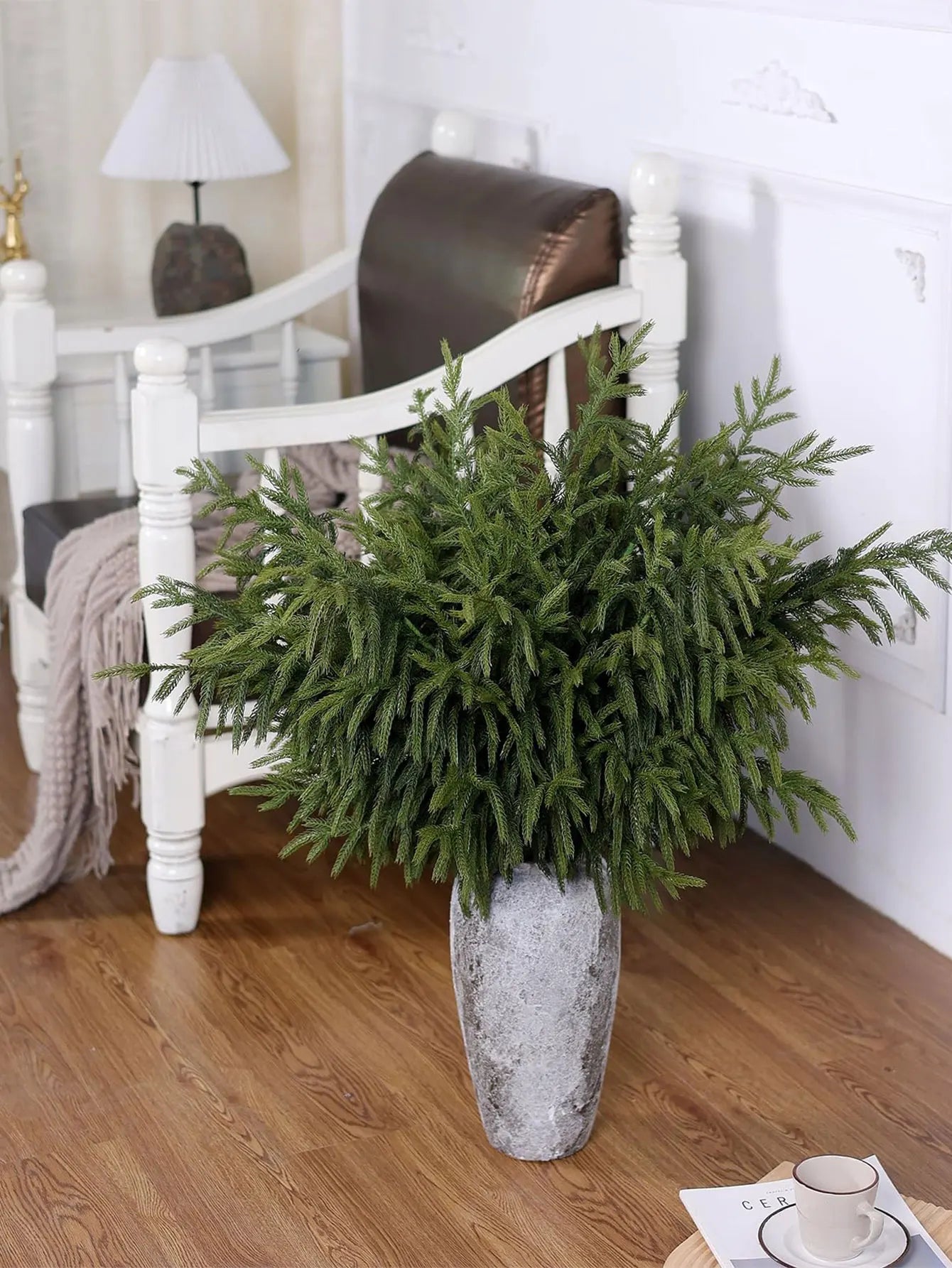 Nutshell real touch faux pine branches arranged in a decorative stone vase in a cozy living room