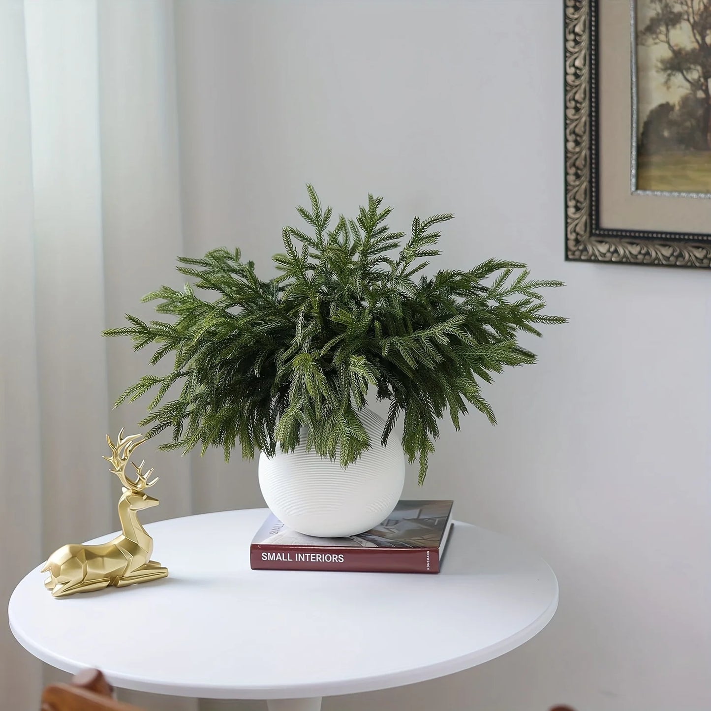 Real touch faux pine branches arranged in a white pot for festive home decor