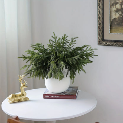 Real touch faux pine branches arranged in a white pot for festive home decor