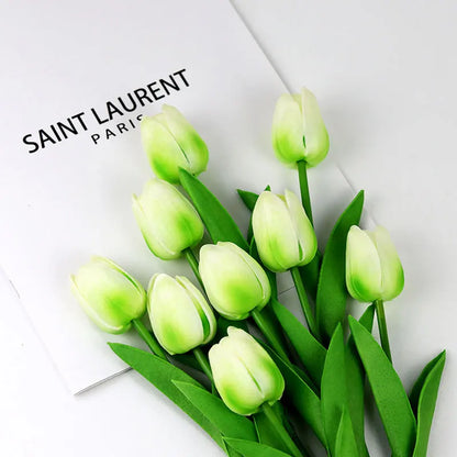 Realistic artificial tulip bouquet with green and white petals arranged next to a Saint Laurent Paris card