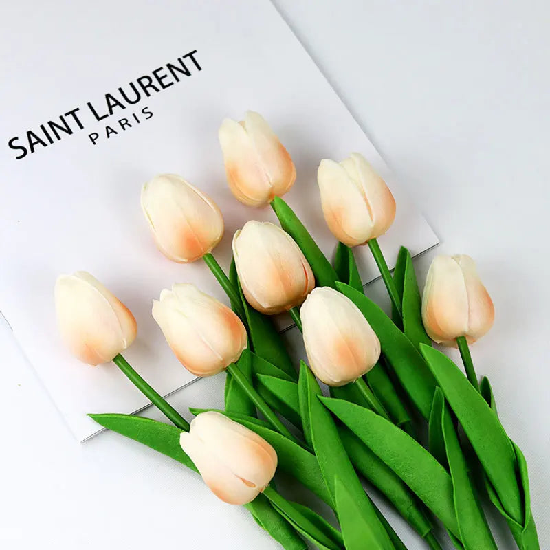 Realistic artificial tulip bouquet in soft peach and cream colors with vibrant green leaves