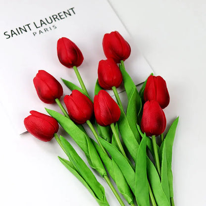 Realistic artificial tulip bouquet in vibrant red with lush green leaves for decorative purposes