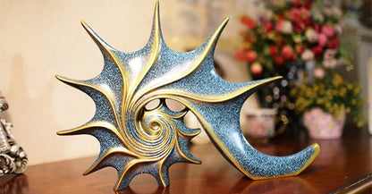 Nutshell resin conch Nordic statue decor with gold and blue spiral design on wooden surface