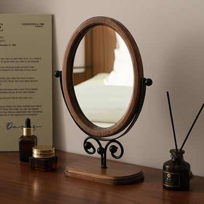 Elegant rotating iron frame mirror on a wooden table with decorative items for home decor