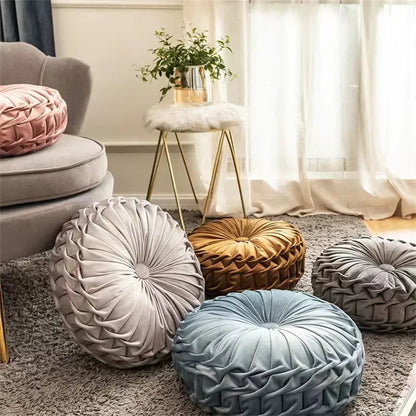 Nutshell round pumpkin pillow collection in various colors including pink, gray, blue, and gold on a living room carpet