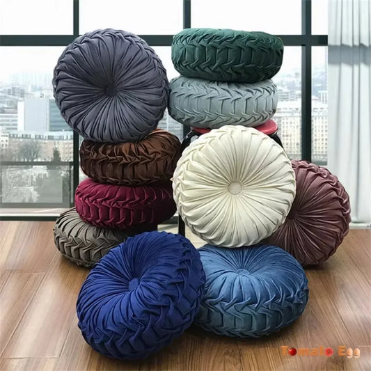 Nutshell round pumpkin pillow collection in various colors stacked in a bright room
