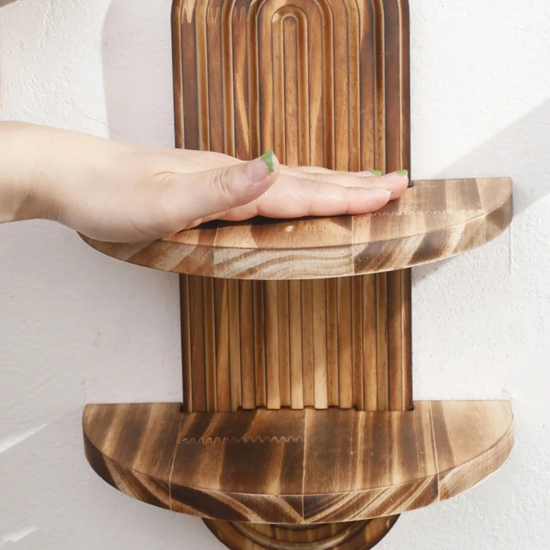 Nutshell wooden wall shelf two tier curved burnt wood with vertical slatted back shown with hand for scale