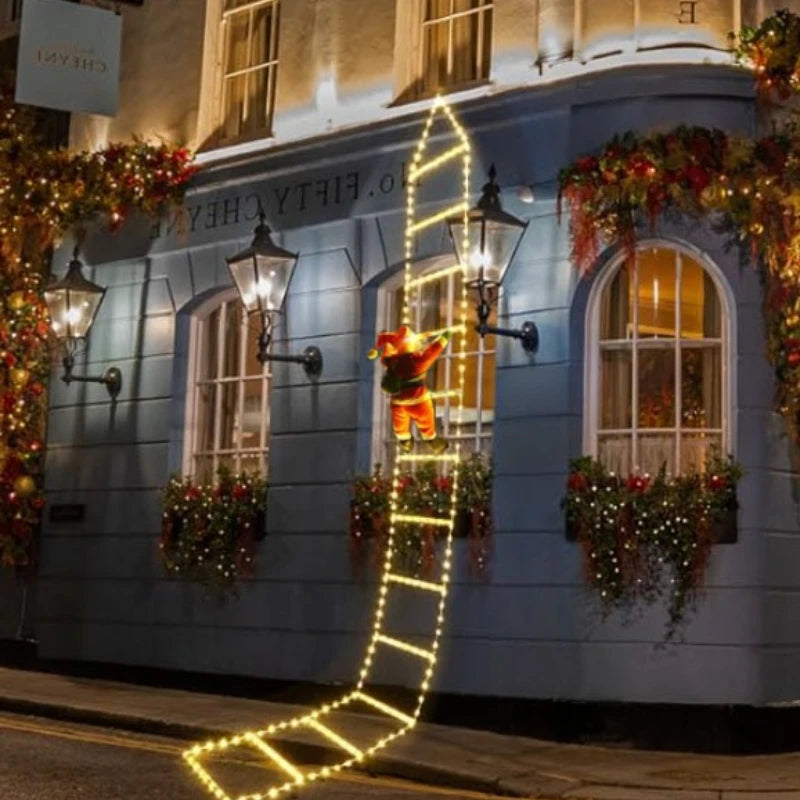 Santa climbing ladder Christmas decoration illuminated outside a festive building
