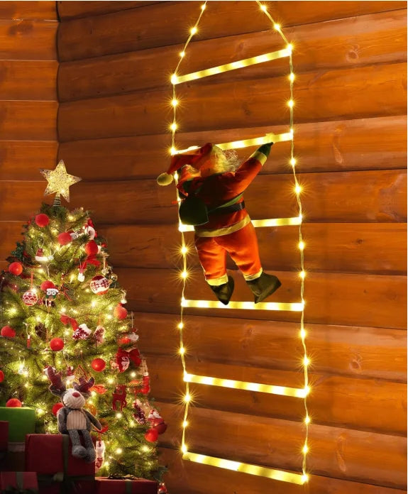 Santa climbing ladder Christmas decoration with lights on a wooden wall next to a festive tree