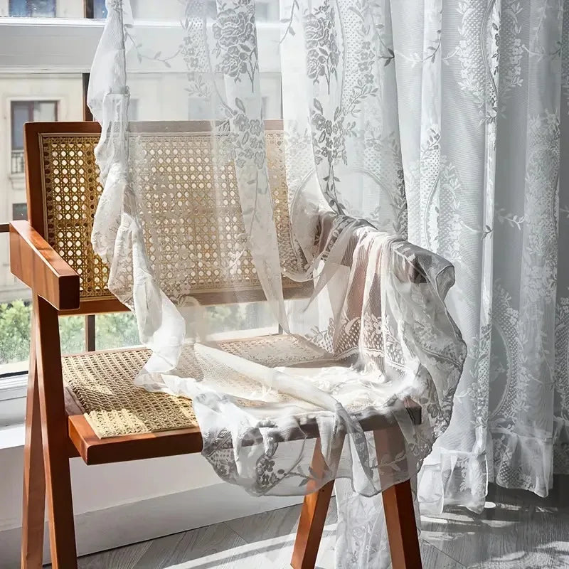 Nutshell Ruffled Floral Sheer Curtain draped over cane wood chair by sunlit window with delicate ruffle hem