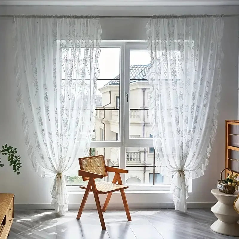 Nutshell Ruffled Floral Sheer Curtain panels in white tied back at a bright window with wooden chair