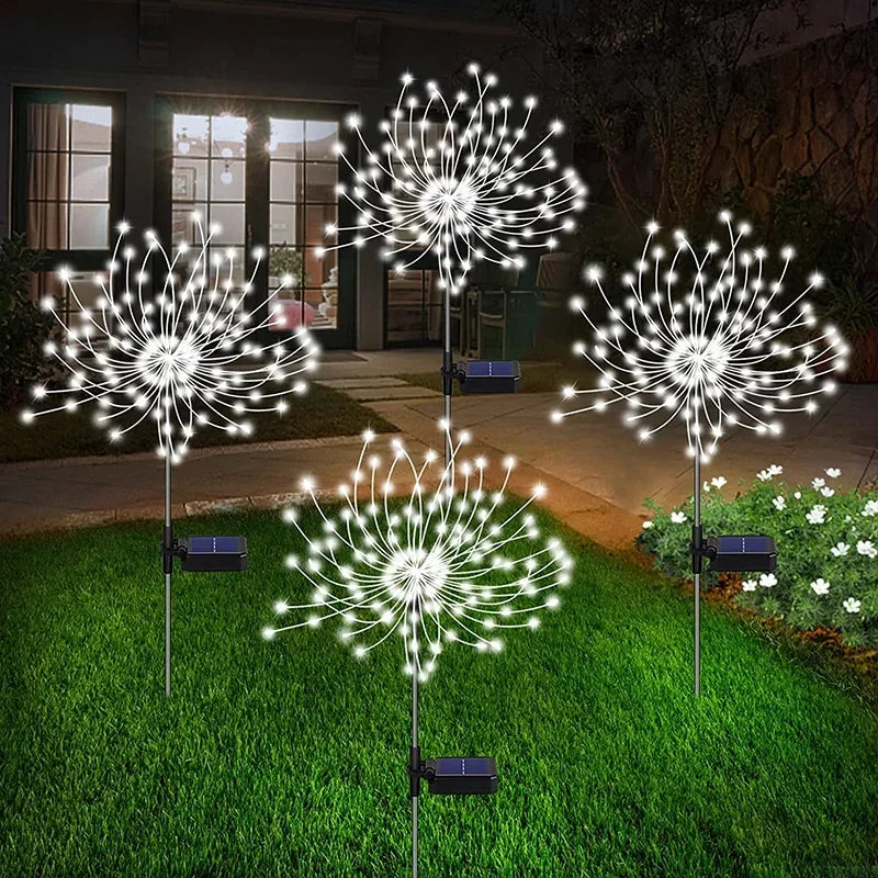 Solar firework garden lights illuminating a lawn with unique dandelion designs at night