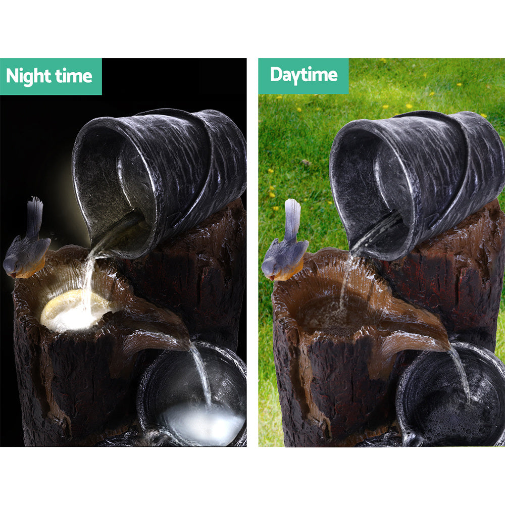 Nutshell Solar Fountain Water Feature showing flowing water from tilted bucket with bird at night and daytime