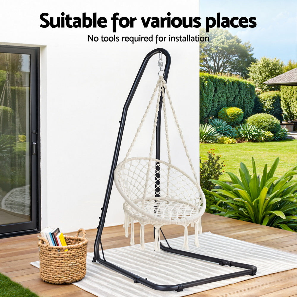 Nutshell white macrame hammock chair with stand on black metal frame on patio deck with outdoor rug and garden view