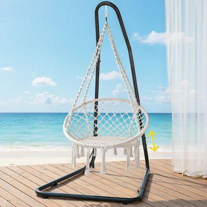 Nutshell white macrame hammock chair with stand on black metal frame tasseled fringe beach view